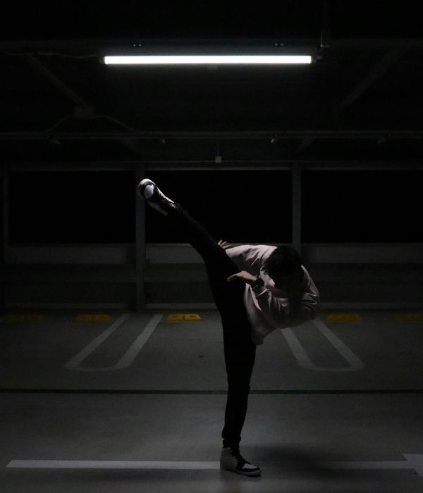 Man performing a controlled strength exercise in a dark room with green light.